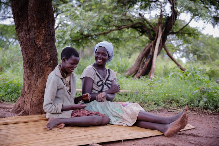Grace chats with her mother at their home. She contracted the disease in 2005. Image by Esther Ruth Mbabazi. Uganda, 2019. 