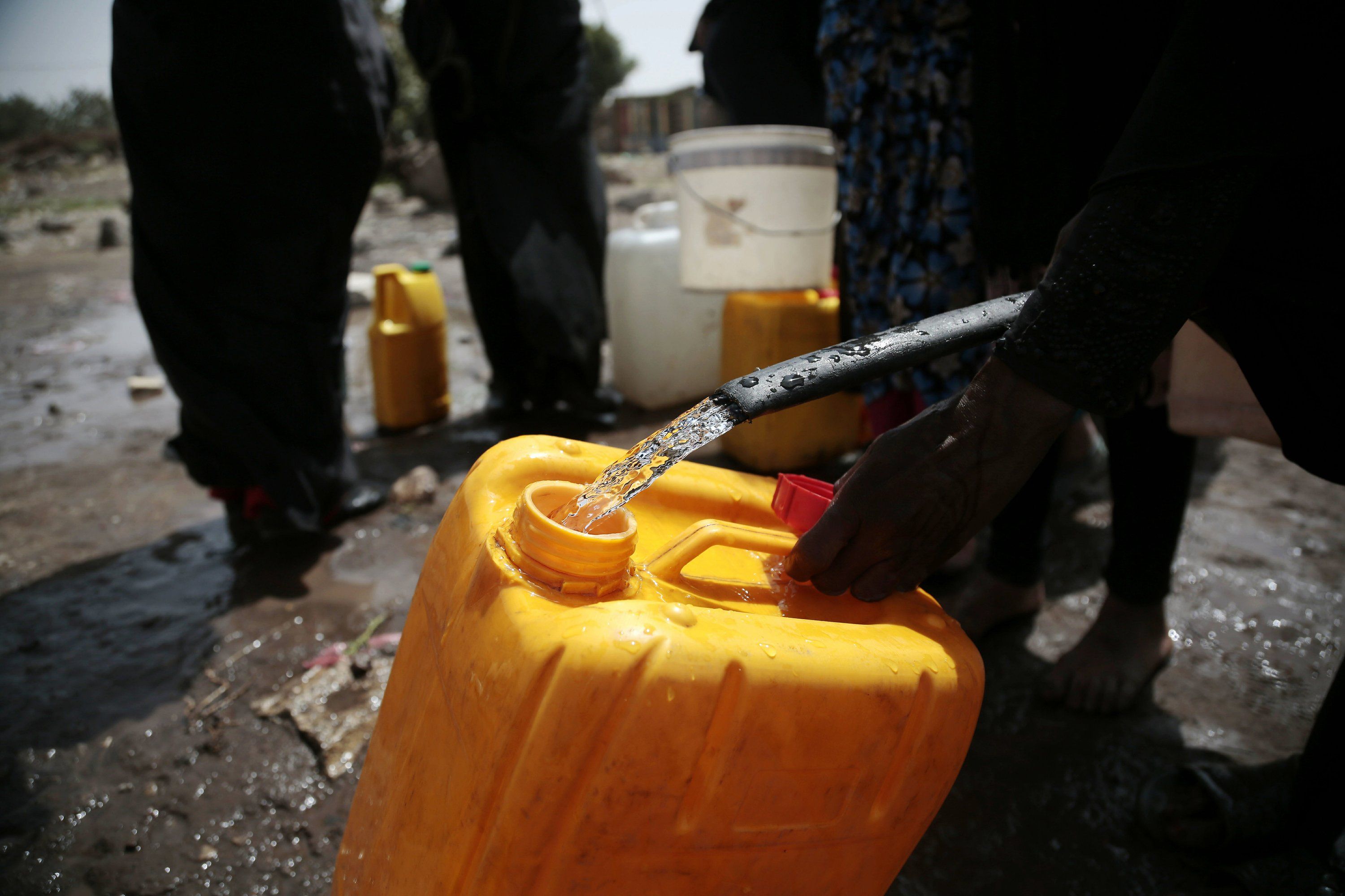 In this July 12, 2017 file photo, a woman fills a jerrycan with water from a well that is alleged to be contaminated with the bacterium Vibrio cholera, on the outskirts of Sanaa, Yemen. An Associated Press investigation finds that Yemen’s massive cholera epidemic was aggravated by corruption and official intransigence. The investigation has found that both the Iranian-backed Houthis rebels and their main adversary in the war—the U.S.— and Saudi-backed government that controls southern Yemen—impeded efforts by relief groups to stem the epidemic. Image by Hani Mohammed/AP. Yemen, 2017.