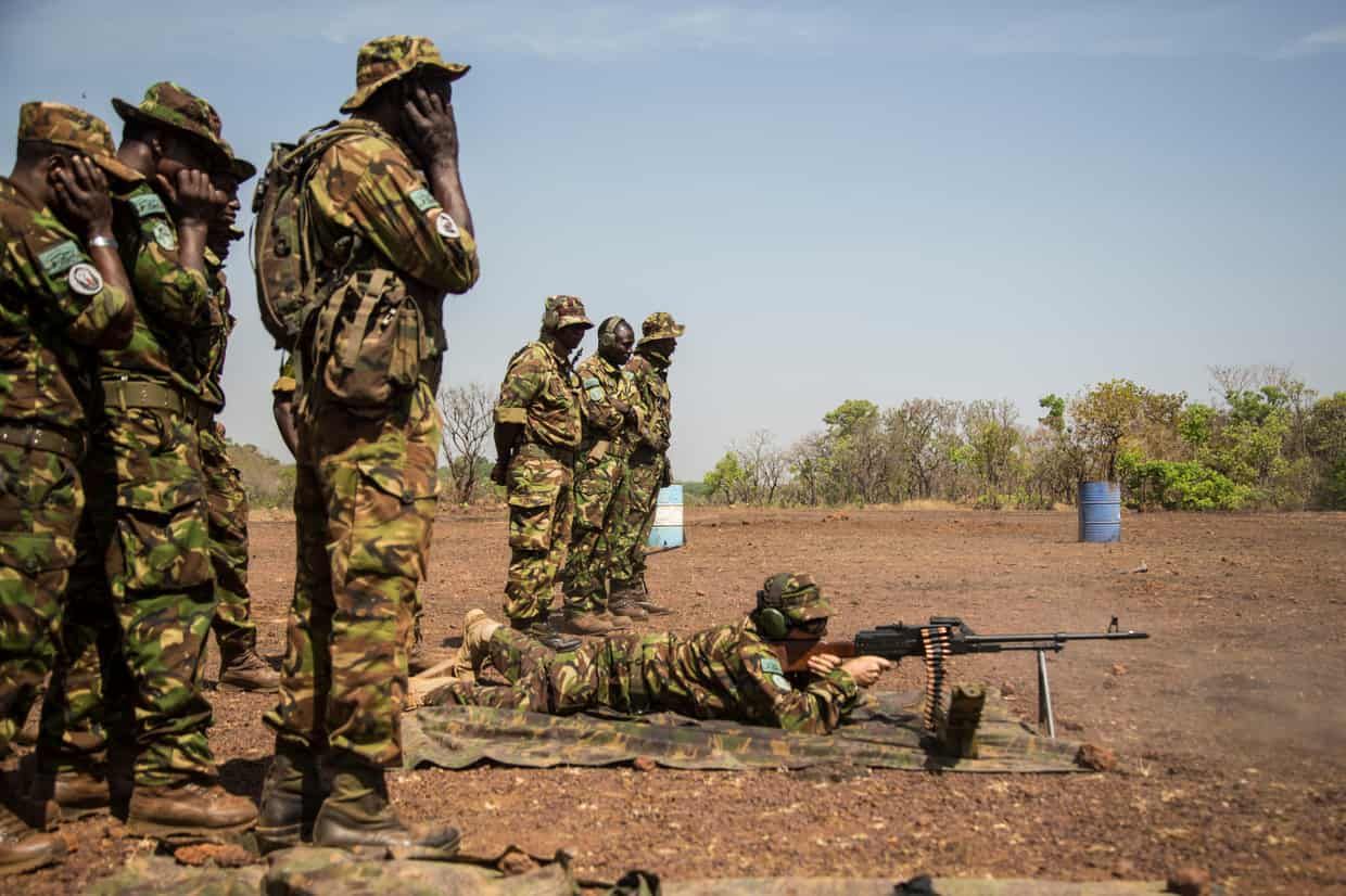 Rangers cover their ears as an assistant law-enforcement manager fires one of the powerful machine-guns at Chinko’s shooting range. Image by Jack Losh. Central African Republic, 2018.
