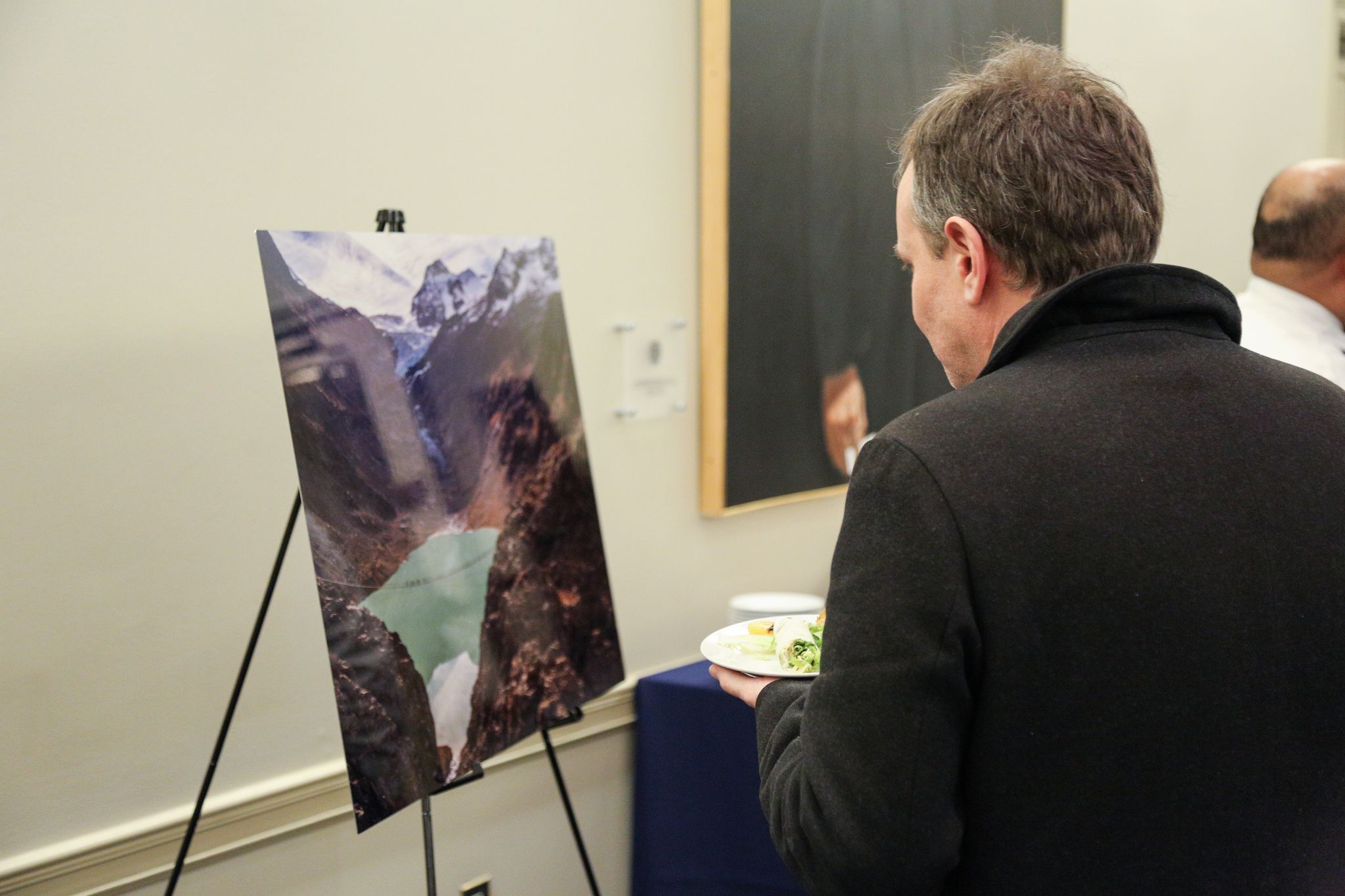 Event attendees browse photos and enjoy post-panel reception. Image courtesy of GU Berkley Center. USA, 2019.  