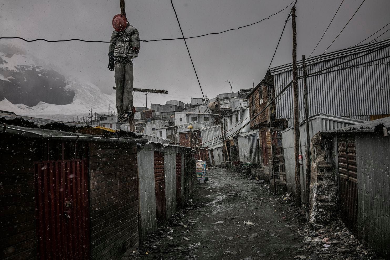 An effigy hangs from a pole as a warning to criminals. Mob justice and these kinds of warnings are common in communities in Peru and Bolivia. A reported 10 police officers keep the peace here. The presence of large quantities of gold and widespread alcohol consumption make crime a major issue in this Andean settlement. Peru, 2019. Image by James Whitlow Delano.