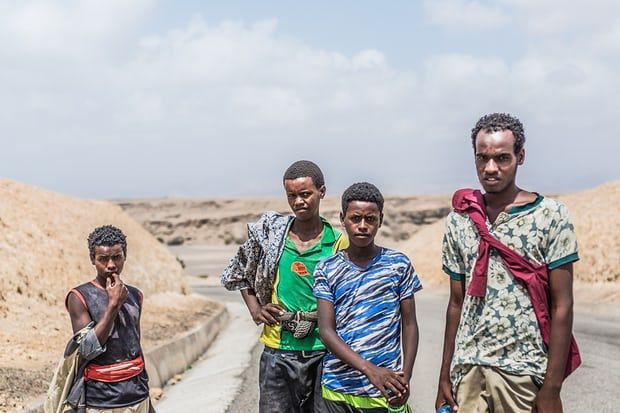 Four young migrants, from the Ethiopian region of Oromia, pictured a few kilometres north of Tadjoura en route to Obock, their final coastal destination. Image by Charlie Rosser. Djibouti, 2018.