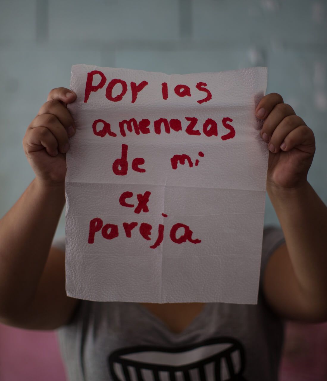 María, 22.

The napkin reads: "because of the threats by my ex-boyfriend." She lives in fear of her ex-partner, an MS-13 gang member whose violence led her to a suicide attempt at age 15. From time to time, she thinks of killing herself when she realizes that she must face life on her own and without the support of her partner, who was killed by members of the other gang, Barrio 18. She currently resides in the United States, where she is requesting asylum. Although she says she feels peace, she is still afraid.

Image by Almudena Toral. El Salvador, 2018.