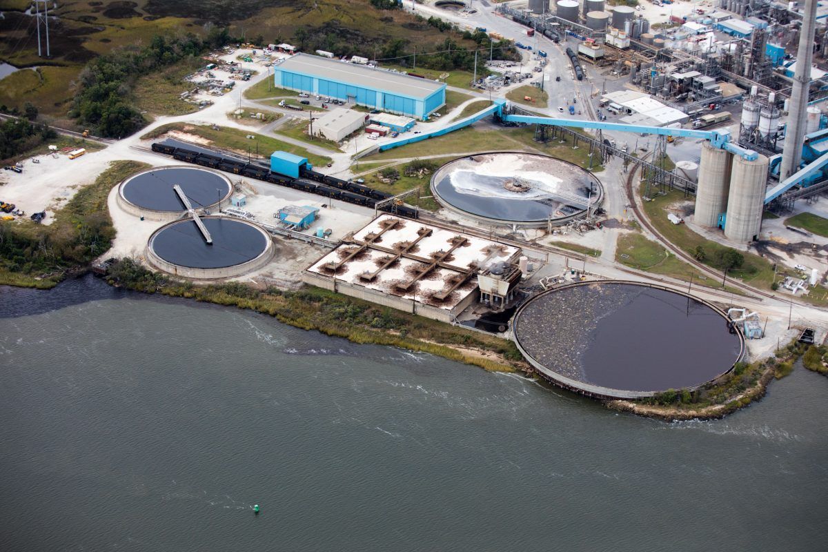 This wastewater treatment plant in North Charleston, South Carolina, is part of a facility owned by WestRock, a manufacturer of corrugated cardboard and other paper products. The cities of North Charleston and Charleston spread across a peninsula that was built on a wetland beginning 350 years ago. The peninsula is bounded by the Ashley and Cooper Rivers, just inland of the Atlantic, and residents have battled chronic flooding since the beginning. Industrial sites replacing wetlands in the region are making the shoreline more impermeable, increasing flooding. Rising water is compounding the problem. Image by Alex MacLean. United States, 2019.