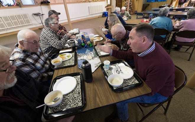 Dairy farmer Randy Roecker, right, talks with retired dairy farmer Hank Elfers, second from left, at St. Peter's Lutheran Church in Loganville. Roecker helped organize "Farm Neighbors Care" events to help farmers who need support. Image by Mark Hoffman. United States, 2020. 