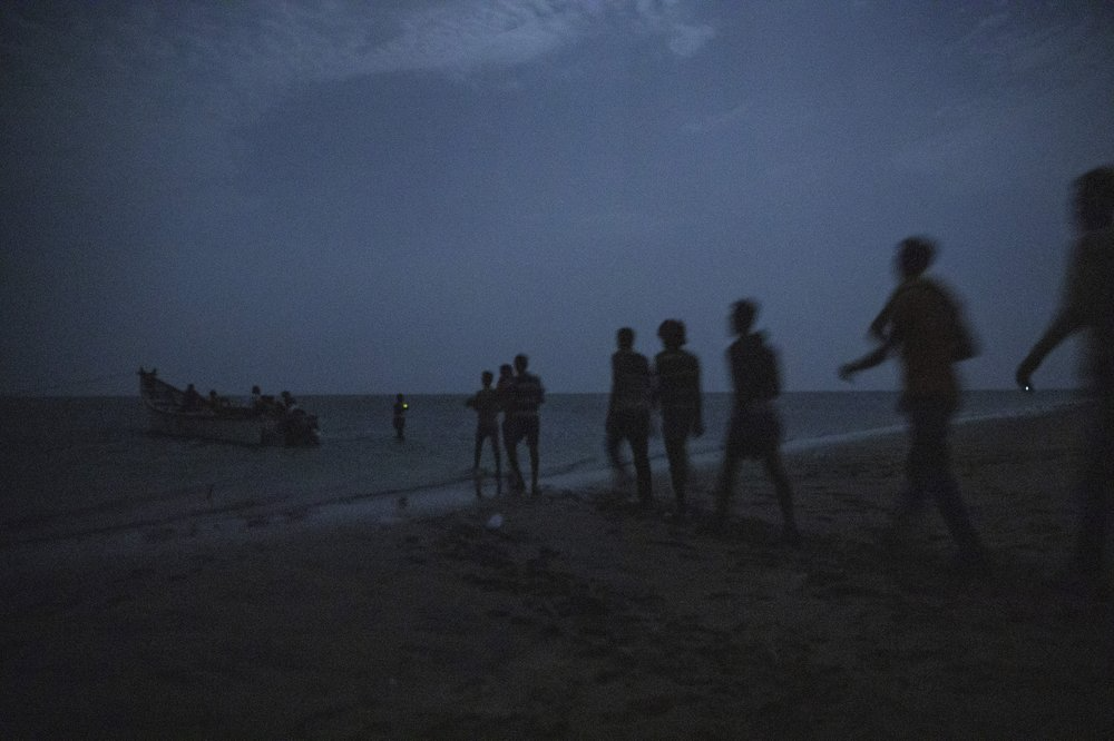 Ethiopian migrants line up to board a small boat in the uninhabited coast outside the town of Obock, the shore closest to Yemen. Image by Nariman El-Mofty. Djibouti, 2019.
