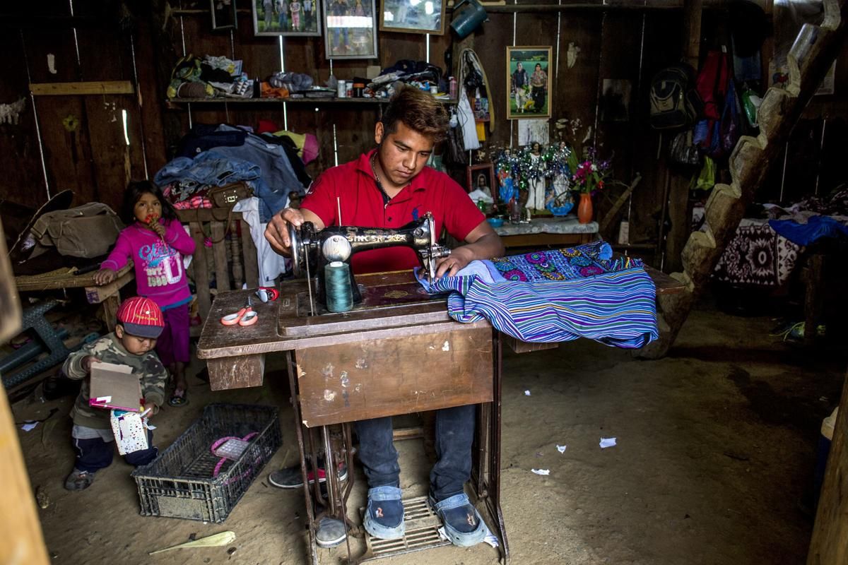 Pascual Alonzo Alonzo, 19, works with his sewing machine at home in Bulej. The lack of jobs drives many people to the U.S. Image by Simone Dalmasso. Guatemala, 2019.