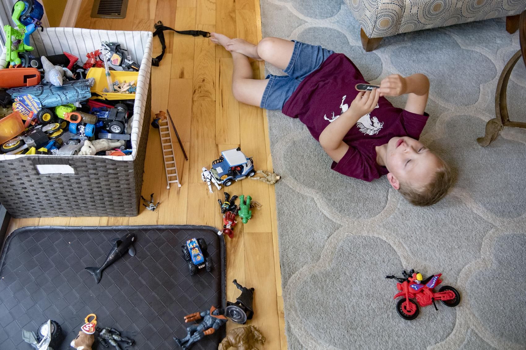 Elias Camacho, 4, plays with toys in the living room of his home in Swannanoa on June 30, 2020. Elias recently had to switch child care centers after the one he was attending closed due to low enrollment after the COVID-19 pandemic. Image by Angeli Wright/Asheville Citizen Times/North Carolina News Collaborative. United States, 2020.

