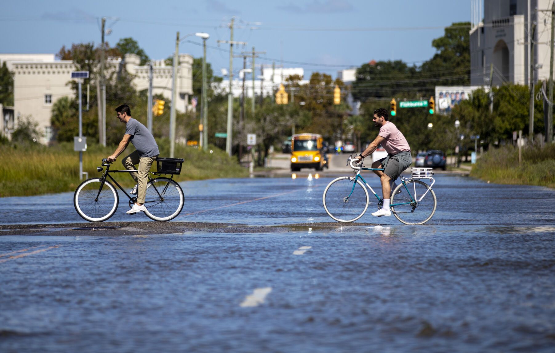 Bicyclists pedal through floodwater at the intersection of Hagood Avenue and Line Street on Monday, Sept. 21, 2020, in Charleston. Image by Andrew J. Whitaker / Post and Courier. United States, 2020.