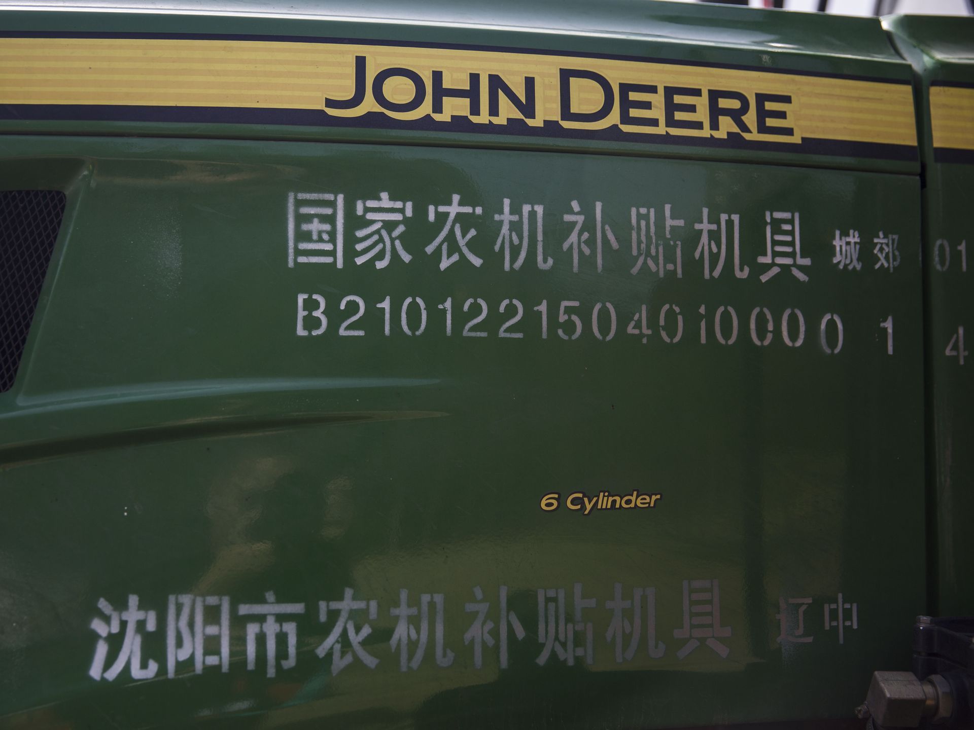 Mandarin characters accompany the English John Deere logo on a tractor set up for display during the groundbreaking of the China-U.S. Demonstration Farm on Saturday, Sept. 23, 2017, in Luanping County, Hebei, China. Image by Kelsey Kremer.