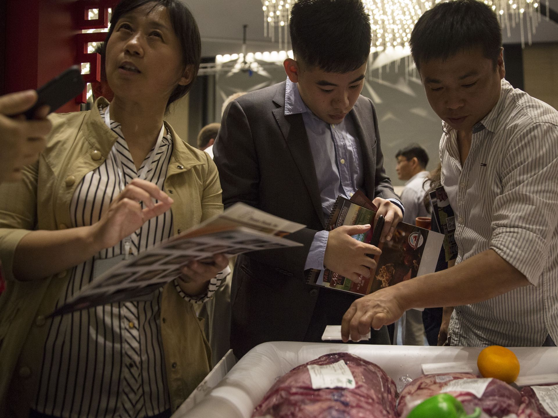 Chinese buyers take closer look at cuts of U.S. beef are set out on display at the China, U.S. beef road show on Monday, Sept. 25, 2017, at the Intercontinental Hotel in Beijing, China. The road show was meant to introduce Chinese buyers to U.S. beef after the recent opening of that market. Image by Kelsey Kremer.