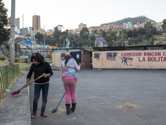 Two girls clean up outside the Jaime Laredo Outdoor Theater in La Paz. Image by Tracey Eaton. Bolivia, 2017.