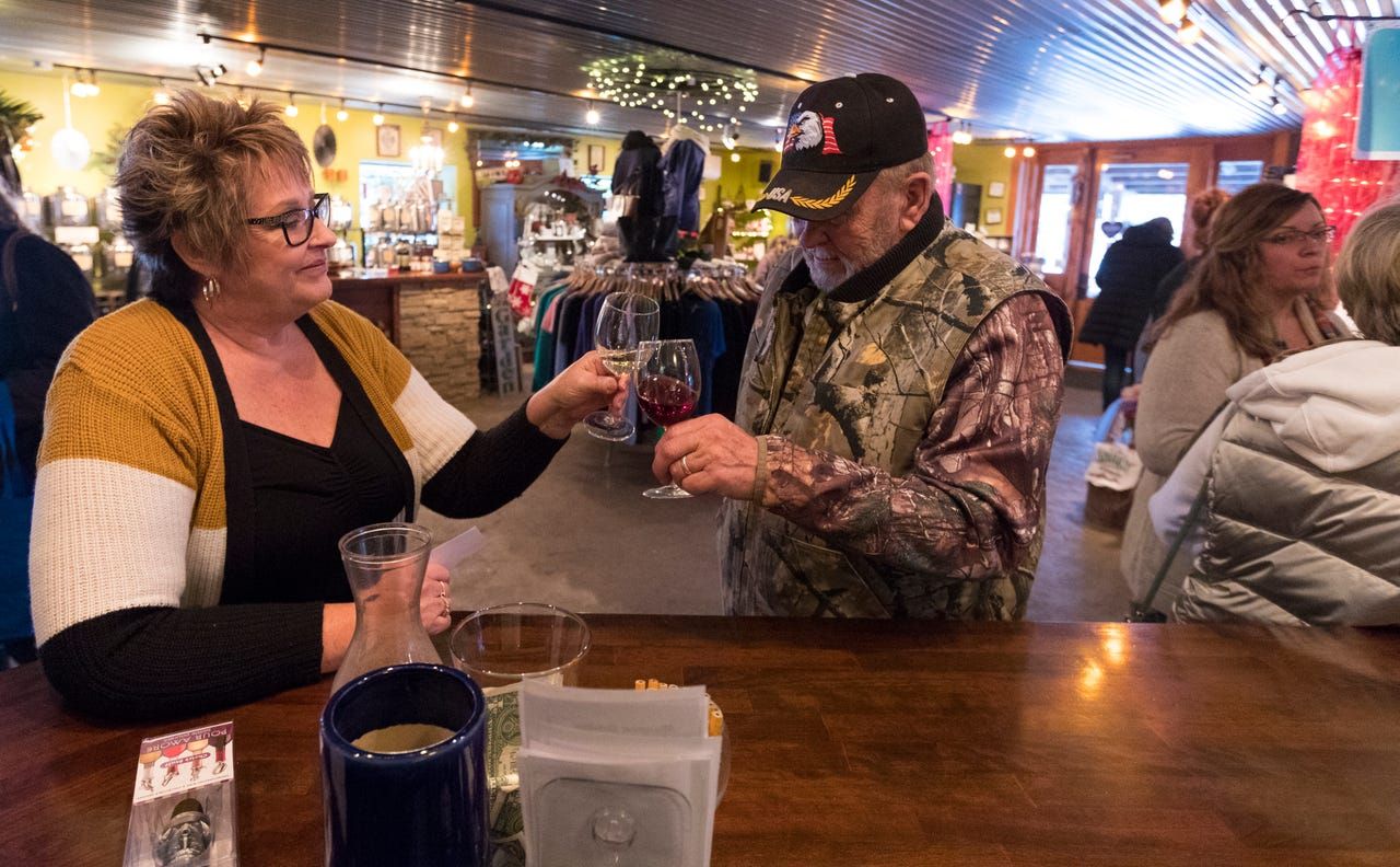 Sheri Rohland shares a toast with customer Garry Jeffers of Sussex at Munson Bridge Winery in Withee. Image by Mark Hoffman. United States, 2019.