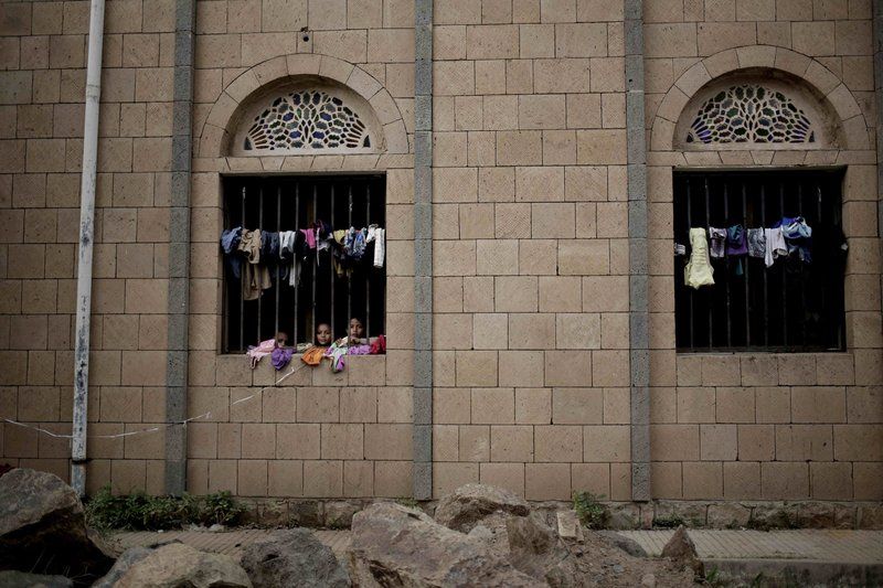 Children look out of their room at a shelter for displaced persons in Ibb. Image by Nariman El-Mofty/AP Photo. Yemen, 2018.