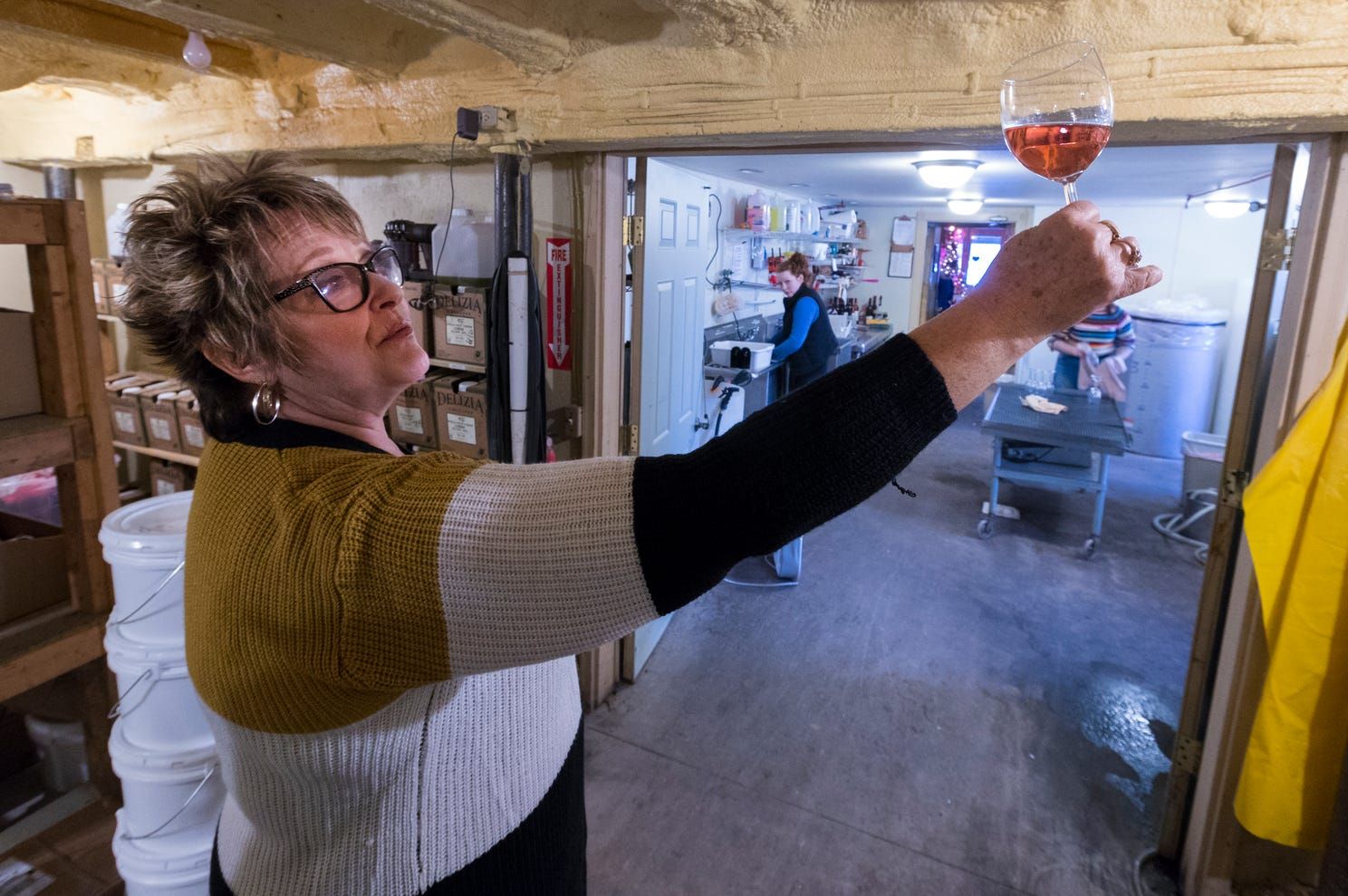Sheri Rohland examines a glass of wine at Munson Bridge Winery. Image by Mark Hoffman. United States, 2019.
