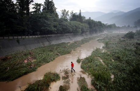 A man walks through one of the drainage channels that make up the Dujiangyan Irrigation system. China. Sean Gallagher, 2010
