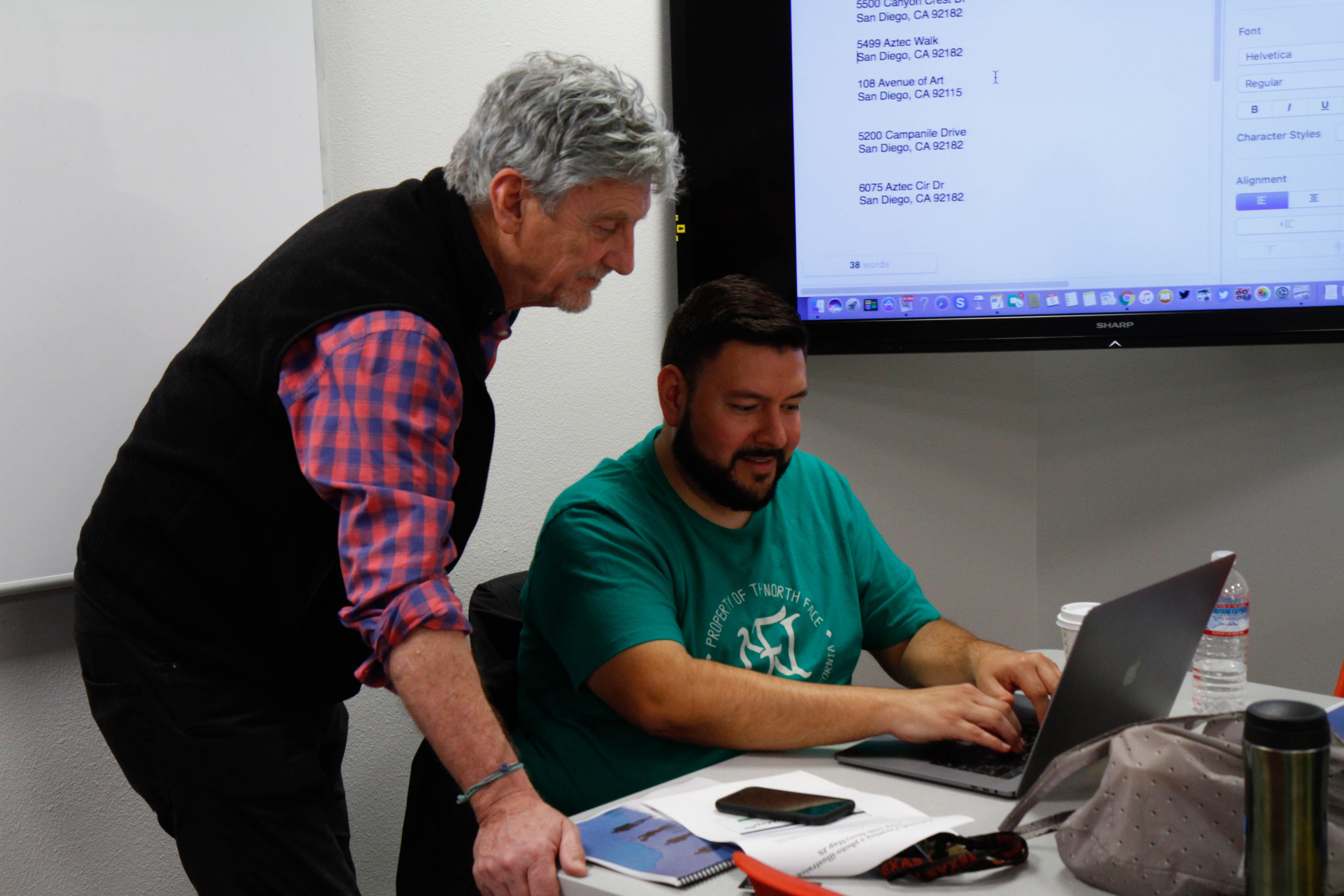 Don Belt advises a faculty member of the diversity department as he creates his San Diego State University Walk on Campus photo slideshow using StoryMap. Image by Lauren Shepherd. United States, 2017.