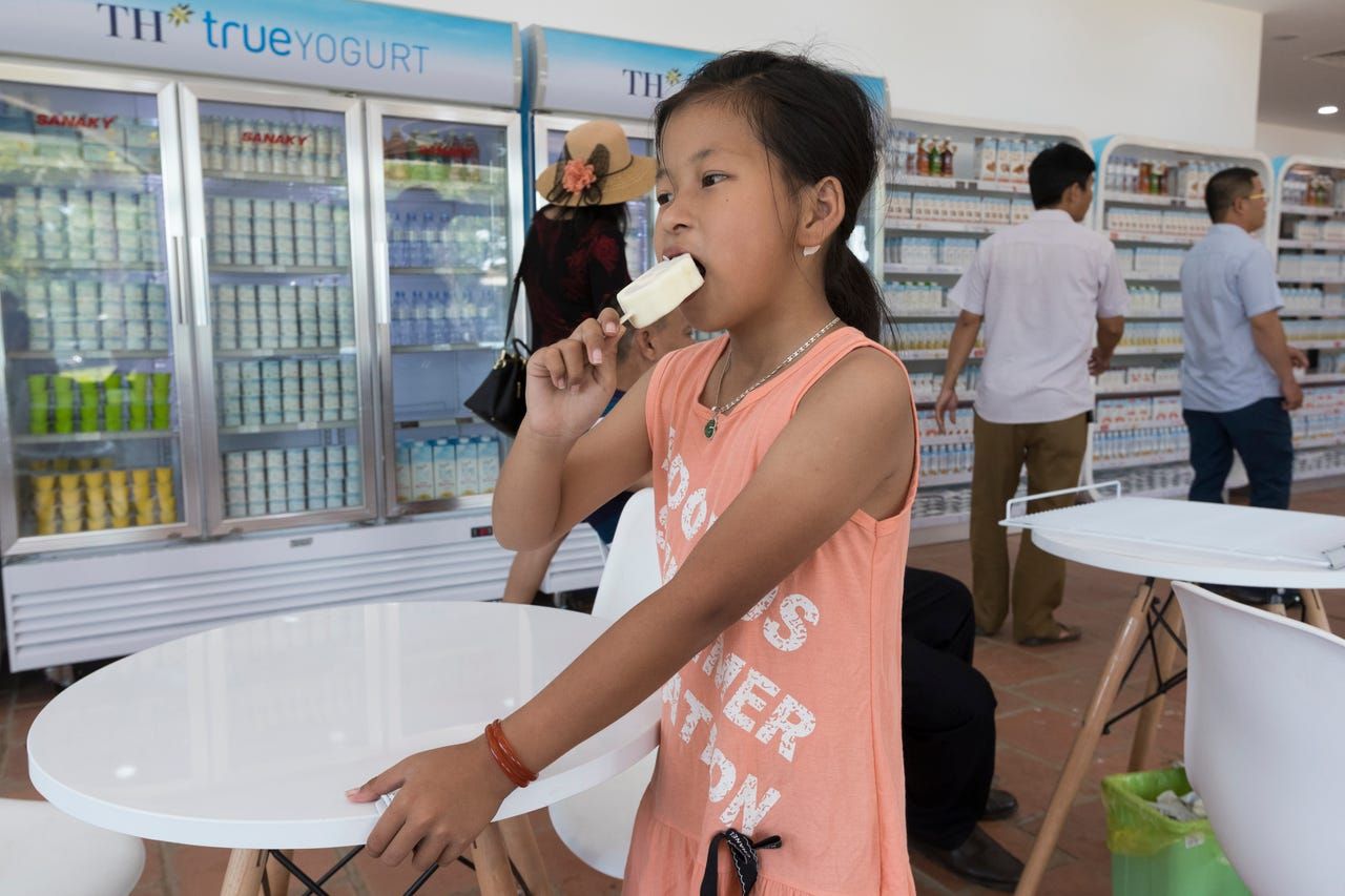 A child eats ice cream in a TH Truemart factory store near TH Milk's operations in Nghia Son, Vietnam. TH true Milk is the most famous milk product in Vietnam. Image by Mark Hoffman. Vietnam, 2019. 