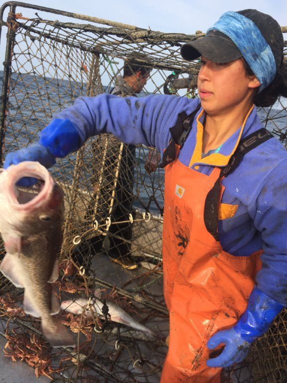 Adelaine Ahmasuk tosses overboard a Pacific cod, one of many caught this summer in the crab pots of the 37 boats she crewed. Image by Hal Bernton. United States, 2019.