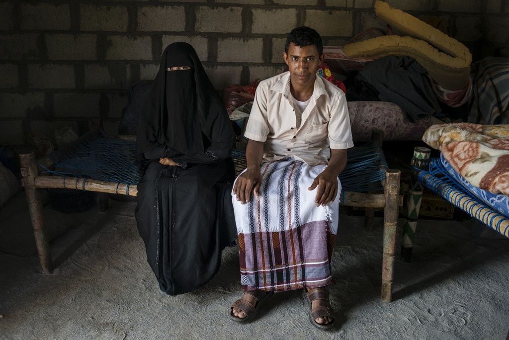 Yahya Ja’afar, 20, sits with his wife Fatum Allam, 20. Image by Alex Potter. Yemen, 2018.