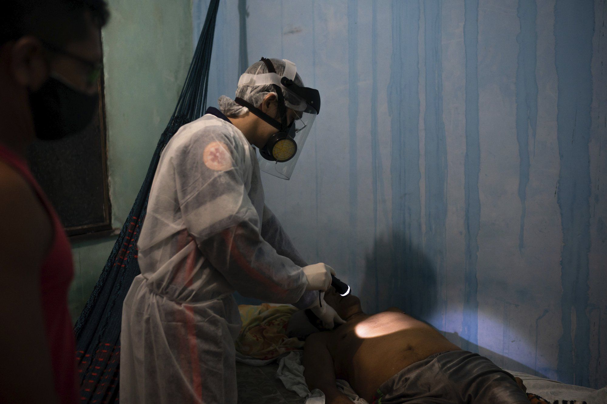 An ambulance doctor checks for the pulse of an elderly man who had just died at his home amid the new coronavirus pandemic in Manaus, Brazil, Thursday, May 21, 2020. Image by Felipe Dana / AP Photo. Brazil, 2020.