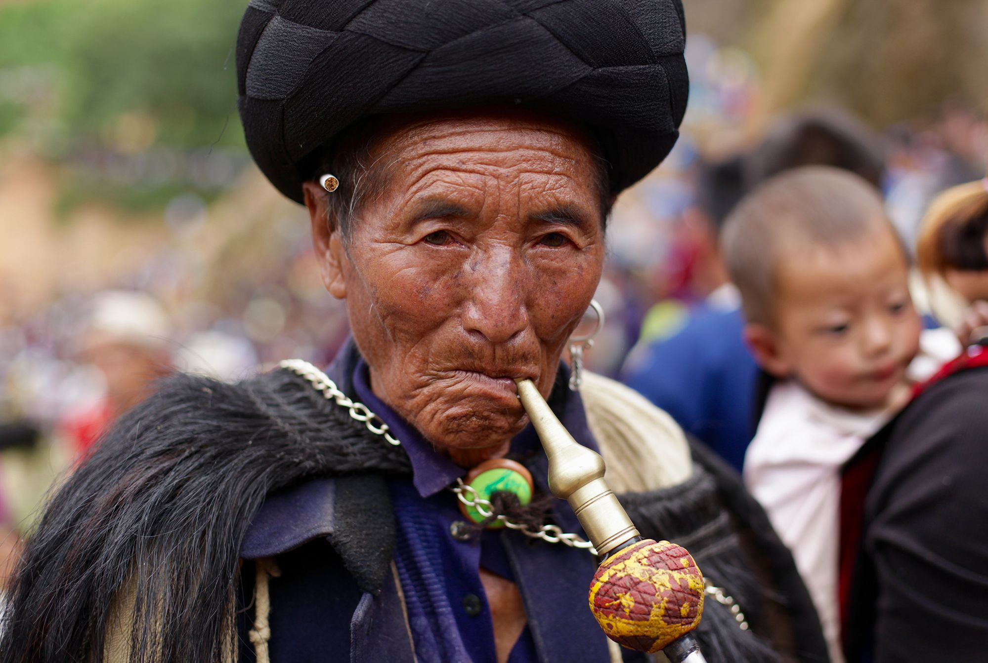 An Yi elder joins the crowds attending torch festival celebrations in Liangshan prefecture Sichuan province. Image by Max Duncan. China, 2016.