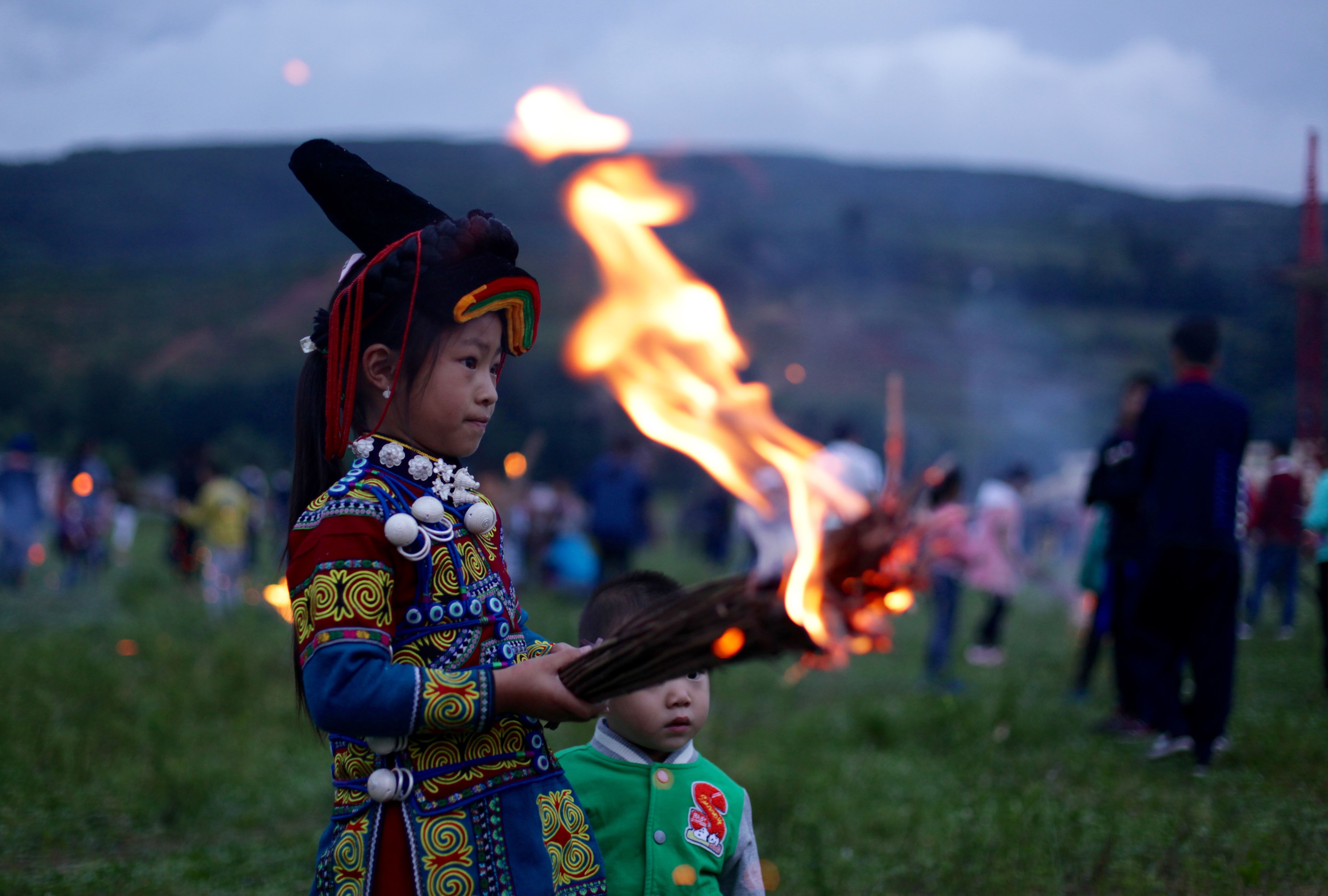 A Yi boy holds a flaming torch during Torch Festival celebrations in Liangshan prefecture, Sichuan province. Image by Max Duncan.  China, 2016.