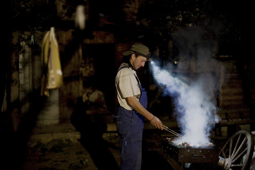 Andrei Gruber roasting meat. Image by Nadia Shira Cohen. Romania, 2011.