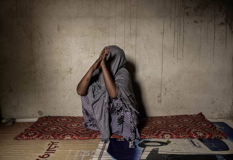 A 25-year old Ethiopian migrant, who was physically abused on her journey from Ethiopia to Yemen, rubs her hands together as she tells her story at a home in Basateen, a district of Aden, Yemen, July 20, 2019. Image by AP Photo / Nariman El-Mofty. Yemen, 2019.