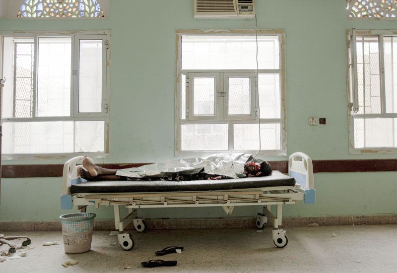 At the Ras al-Ara Hospital, Lahj, Yemen, Ethiopian migrant Dasto Mohammed lies on a gurney, July 26, 2019, after disembarking a boat and feeling sick from the journey. The flow of migrants to the beach is unending. On a single day, the AP witnessed seven boats arrive, each carrying more than 100 people. Mohammed came with her sister to Yemen to go to Saudi Arabia and seek work. Image by AP Photo / Nariman El-Mofty. Yemen, 2019.