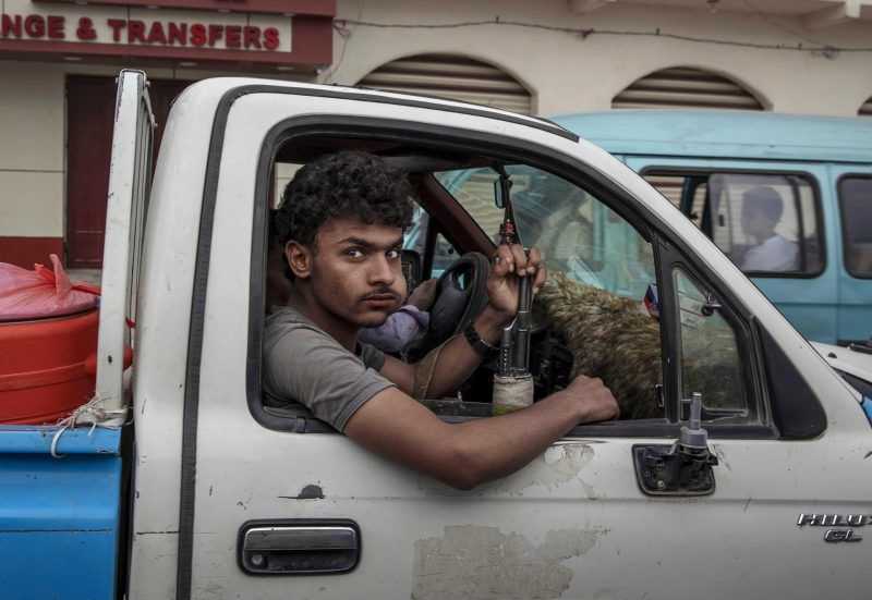 A man holds a weapon, July 30, 2019, in Jawf, Yemen, which is one of the areas where African migrants gather to continue their journey, most hoping to reach Saudi Arabia. Image by AP Photo / Nariman El-Mofty. Yemen, 2019.