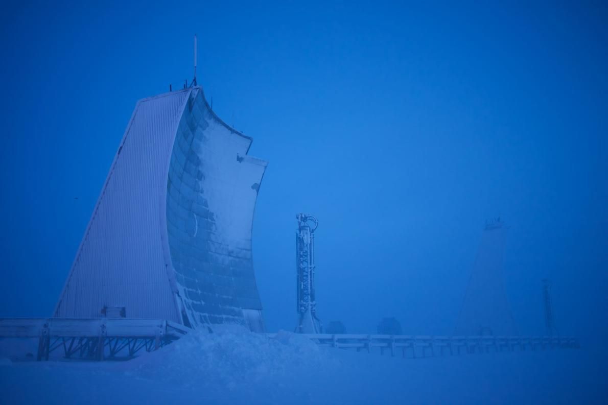 A long-range radar installation rears up from the tundra in Hall Beach, Nunavut, Canada. The radar is one of 50 unmanned surveillance stations that keep watch over North America’s northern frontier, stretching from Canada’s eastern coast to the west coast of Alaska. Called the North Warning System, the radar line is jointly operated by Canadian and U.S. forces under NORAD, the North American Aerospace Defense Command. Image by Louie Palu. Canada, 2018.