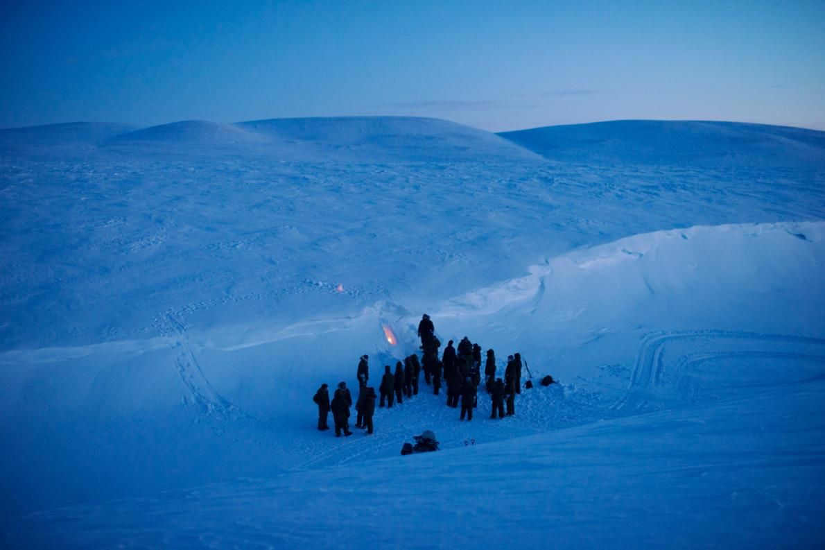 NATO soldiers and airmen learn how to carve a temporary shelter into drifted snow at the Canadian military’s Chrystal City training facility near Resolute Bay in Nunavut. Image by Louie Palu. Canada, 2018.