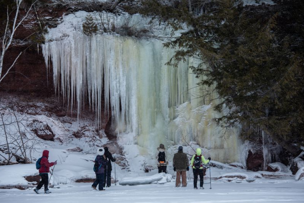 Tourists from Madison, Wisconsin, experience ice formations during a tour of ice caves on the shore of Lake Superior in the Red Cliff reservation in Wisconsin on Feb. 15, 2020. Image by Zbigniew Bzdak/The Chicago Tribune​​​​​​​. United States, 2020.