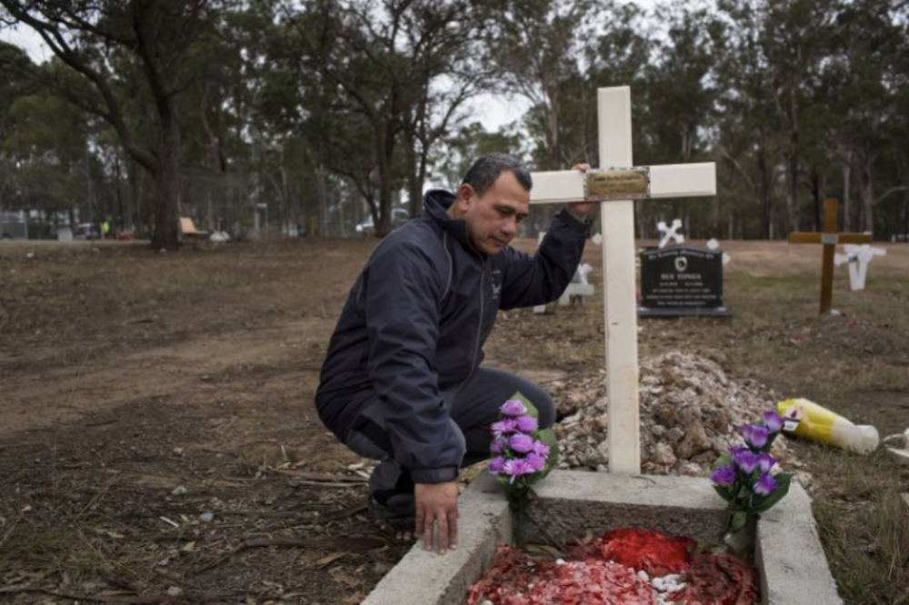 Vaea Togatuki, 48, visits the grave of his son, Junior, who died by suicide on September 11, 2015 while incarcerated in Goulburn’s Correctional Center. Image by David Maurice Smith for The New York Times. Australia, 2018.

