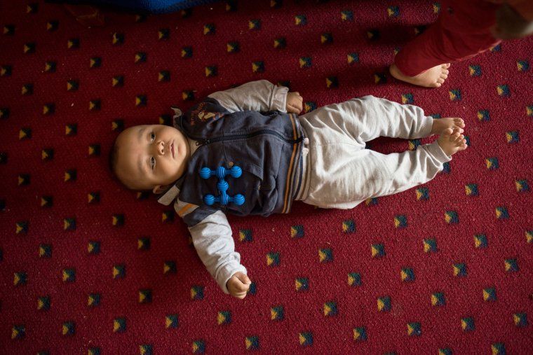 Faraj, who was born in a Greek refugee camp in October, rests after trying to learn to roll over. Image by Lynsey Addario. Greece, 2017.