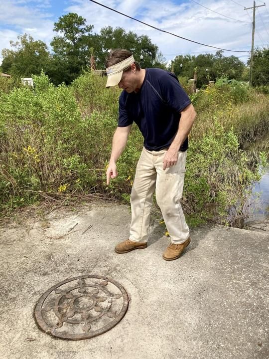 Jimmy “Zeke” Mazyck explains how he found a chokepoint that made his neighborhood off Central Park Drive on James Island flood worse than it should. Image by Tony Bartelme/The Post and Courier Staff. United States, 2020.