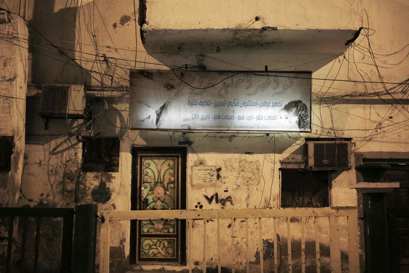 This Feb. 13, 2018, photo shows damage and bullet holes from the country’s civil war outside a women’s hair salon in Aden, Yemen. The mood is eerie on the mostly empty streets of Aden, Yemen’s southern port city and erstwhile seat of government that has suffered three years of civil war. Image by Nariman El-Mofty. Yemen, 2018. 

