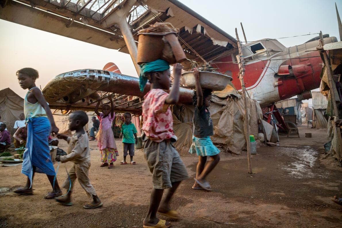 To escape the fighting, tens of thousands of Bangui residents took refuge among wrecked planes and active runways in a camp at the airport, which UN peacekeepers protect. In December the government began giving people at the camp money to resettle. Image by Marcus Bleasdale. Central African Republic.