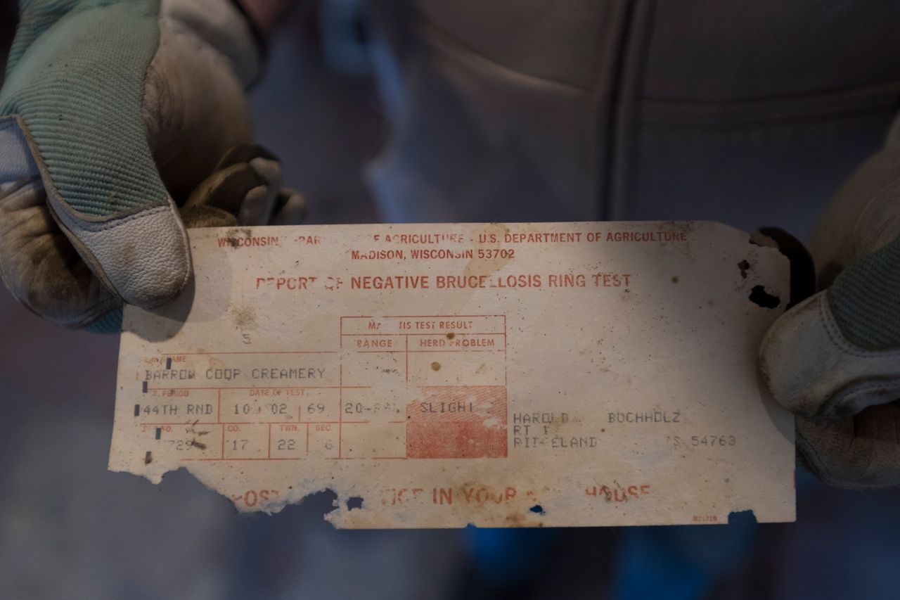 Bruce Drinkman holds a 50-year-old slip for a negative brucellosis test he found at the farm in Ridgeland. Brucellosis attacks the reproductive system of cows and other species of hoofed animals. It also can trigger an infection, undulant fever, in people who have contact with infected animals. Image by Mark Hoffman. United States, 2019.