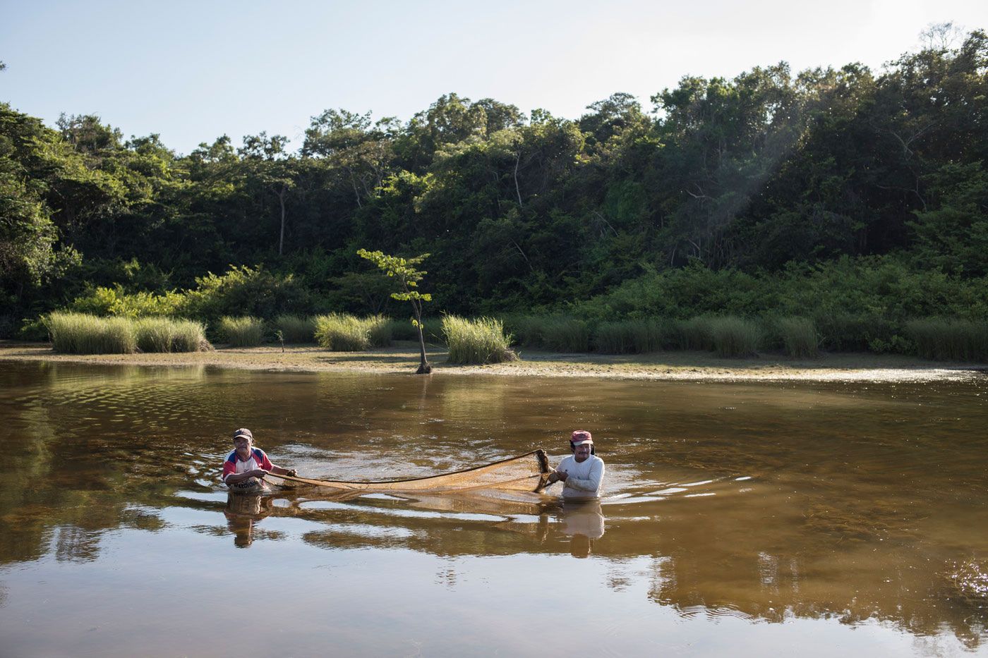 Two members of the Pemón community fishing on the Kukenán River in the Gran Sabana. Image by Fabiola Ferrero. Venezuela, 2020.