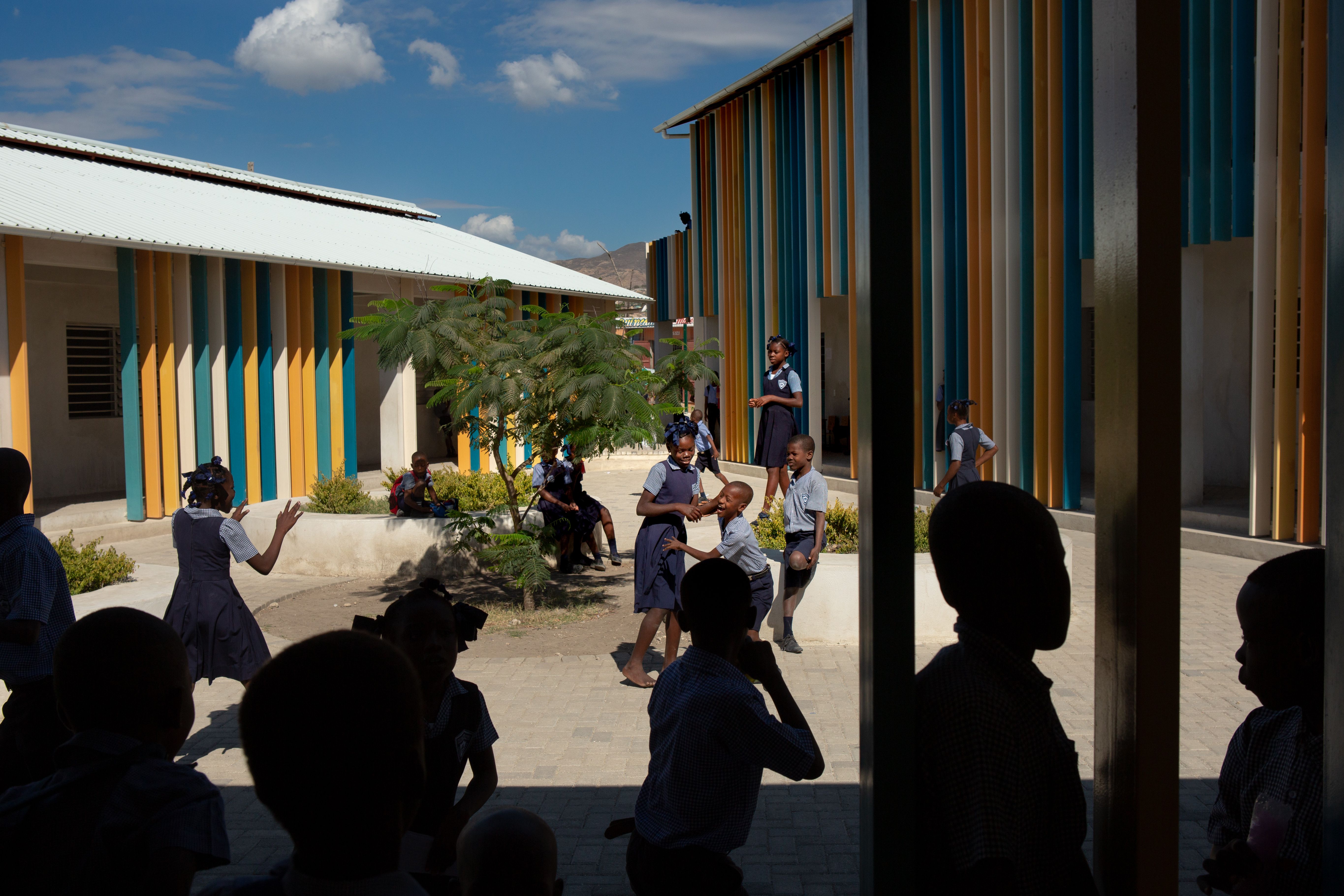 Students begin morning recess at Ecole Fondamentale Complete Breda de Canaan in the Canaan 3 neighborhood. The K-8 facility is the first public school in greater Canaan. Students who score at the top of a competitive entrance exam are accepted to the school, which opened in fall 2018 and already has a long waiting list. Image by Allison Shelley. Haiti, 2019.