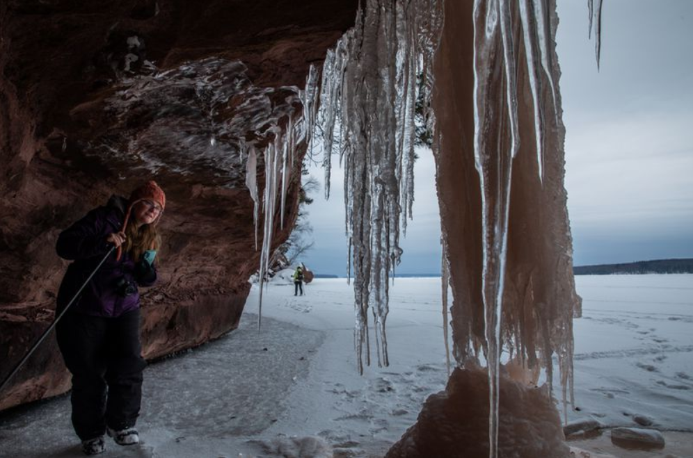 Rene Wagenaar, of Merrill, Wisconsin, examines ice formations during a tour of ice caves on the shore of Lake Superior in the Red Cliff reservation in Wisconsin on Feb. 15, 2020. Image by Zbigniew Bzdak/The Chicago Tribune. United States, 2020.