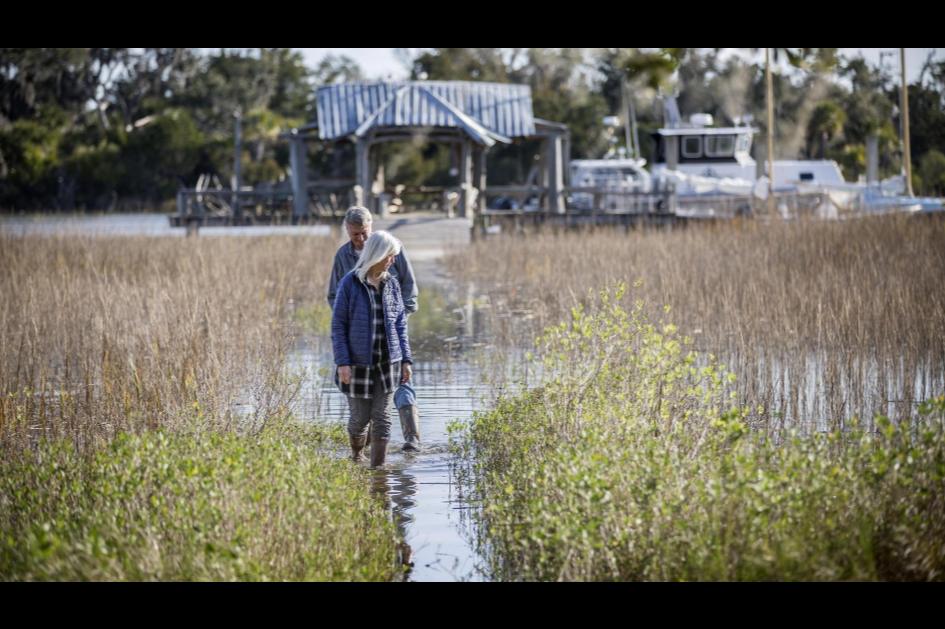 Wanda and David Scott stand on the flooded causeway to their dock at their home on Whitemarsh Island. Image by GPB Photo / Stephen B. Morton. United States, 2020.