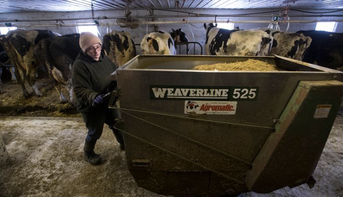 Christy Spexet moves a feed dispenser. Image by Mark Hoffman/The Milwaukee Journal Sentinel. USA, 2019.