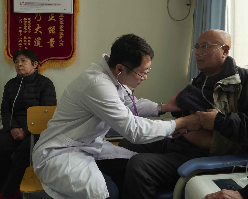 Dr. Li Zhu, a respiratory medicine specialist, listens to the breathing of Li Baozhi, 67, who suffers from chronic obstructive pulmonary disease, or COPD. Image by Larry C. Price. China, 2018.