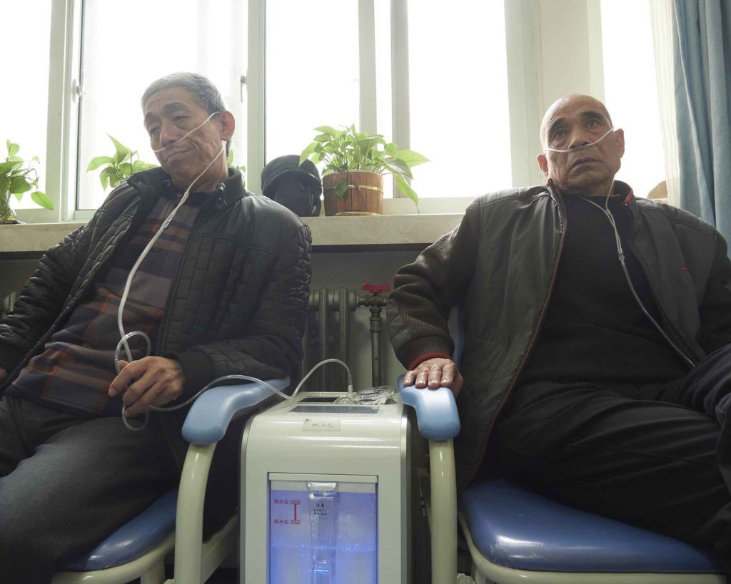 At the First Hospital of Hebei Medical University in Shijiazhuang, patients suffering from a variety of respiratory illnesses line the walls. Image by Larry C. Price. China, 2018.