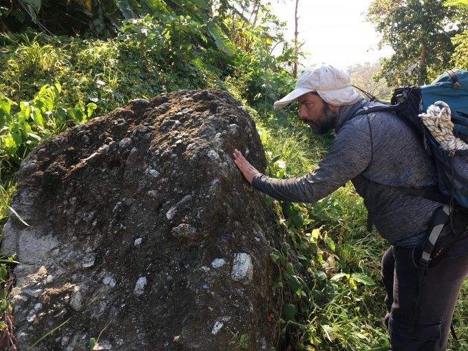 Geologist Felipe Lamus Ochoa examines a volcanic rock near the Gulf of Urabá in northern Colombia. Image by Lizzie Wade. Colombia, 2018.