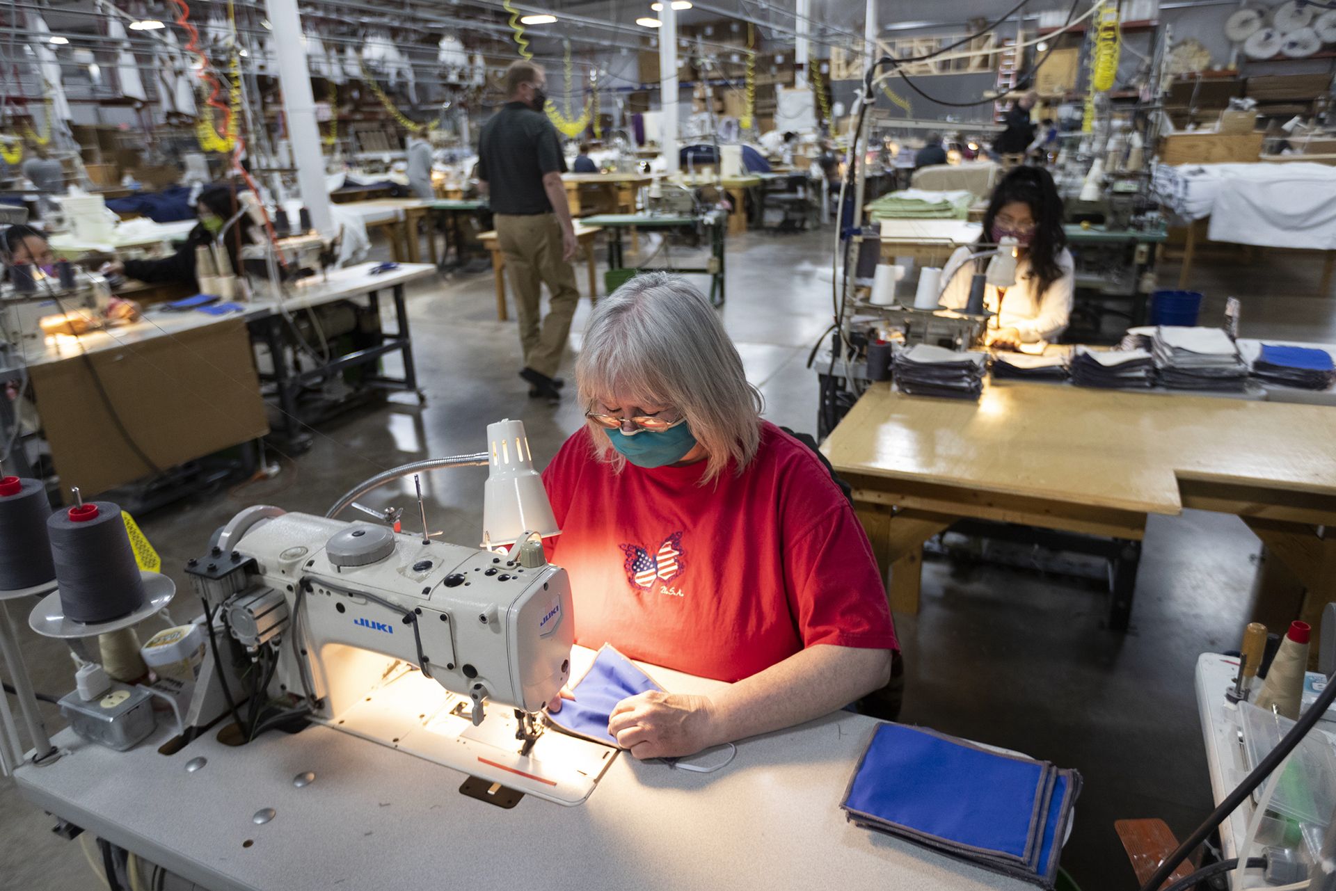 Workers sew non-medical masks on April 23, 2020 at Decorator Industries in Abbotsford, Wis. The company, which normally produces room furnishings for the hotel industry, quickly pivoted to making face masks. Image by Mark Hoffman / Milwaukee Journal Sentinel. United States, 2020.