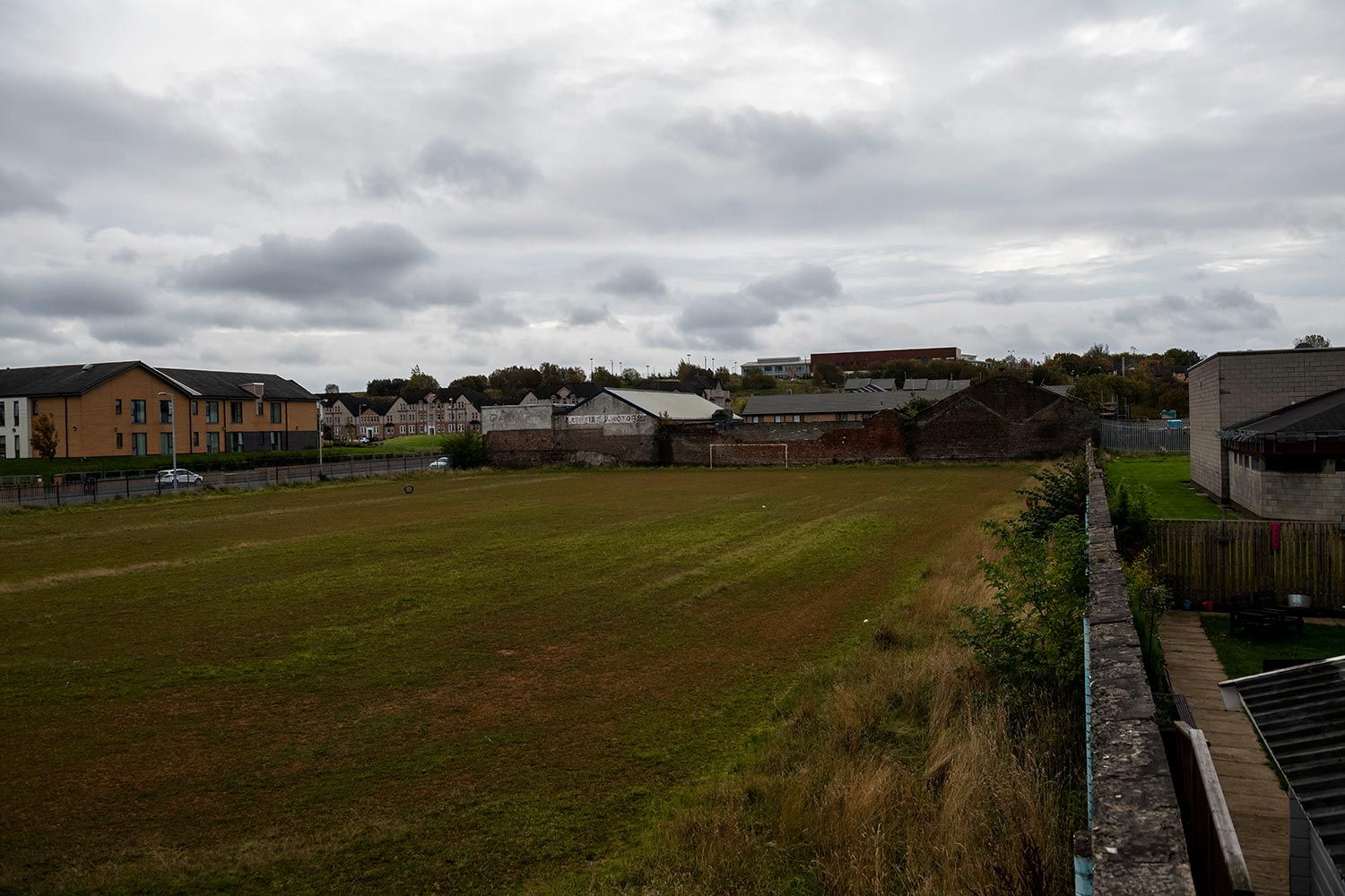 A polluted and fenced-off soccer field owned by Glasgow City Council. The soccer field, which was polluted by an iron industry that left town in the late 1960s, is located behind the Possilpoint Community Centre and will be the future location of a new community facility. Image by Michael Santiago. United Kingdom, 2019.